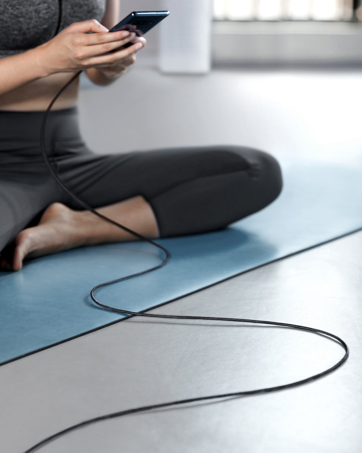 Anker cable for phone charging with user sitting on mat.